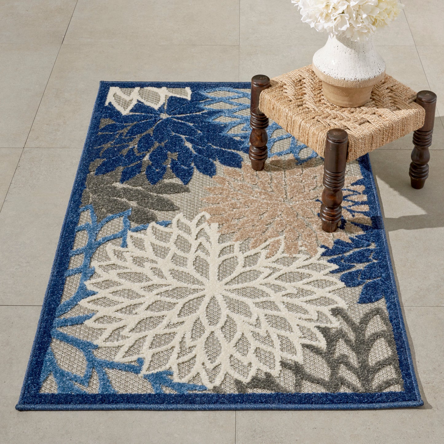 Blue-bordered tropical rug 3' x 4' with oversized white floral petals and beige-gray accents.