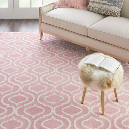 Pink trellis rug beside a beige sofa in a cozy living room.