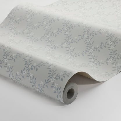Rolled wallpaper featuring a subtle silver-blue leafy vine pattern on a pale gray background.