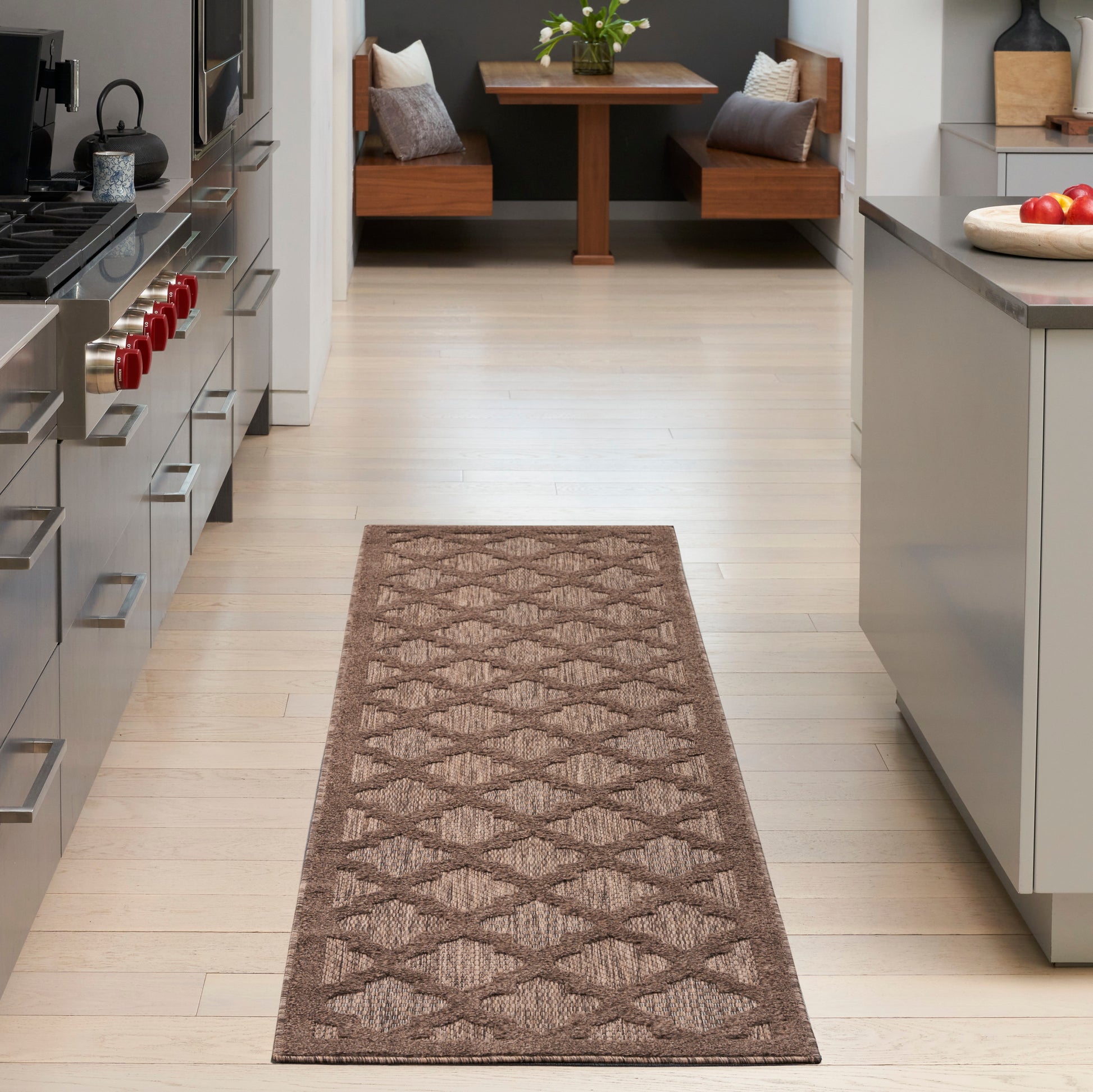 Brown woven runner rug with geometric diamond pattern along a light hardwood kitchen hallway; modern and cozy.
