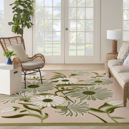 Bright outdoor living area with a beige floral rug featuring white daisies and green vines, wicker chairs, a sofa, and glass doors.