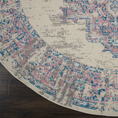 Round rug with distressed Persian-inspired pattern in pink, blue, taupe on beige, placed on dark wood floor.