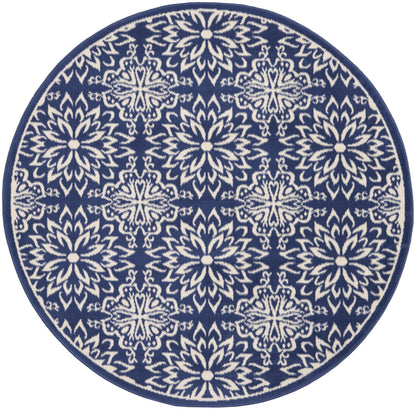 Round navy rug featuring white mandala-style floral motifs in a repeating pattern with a solid border.