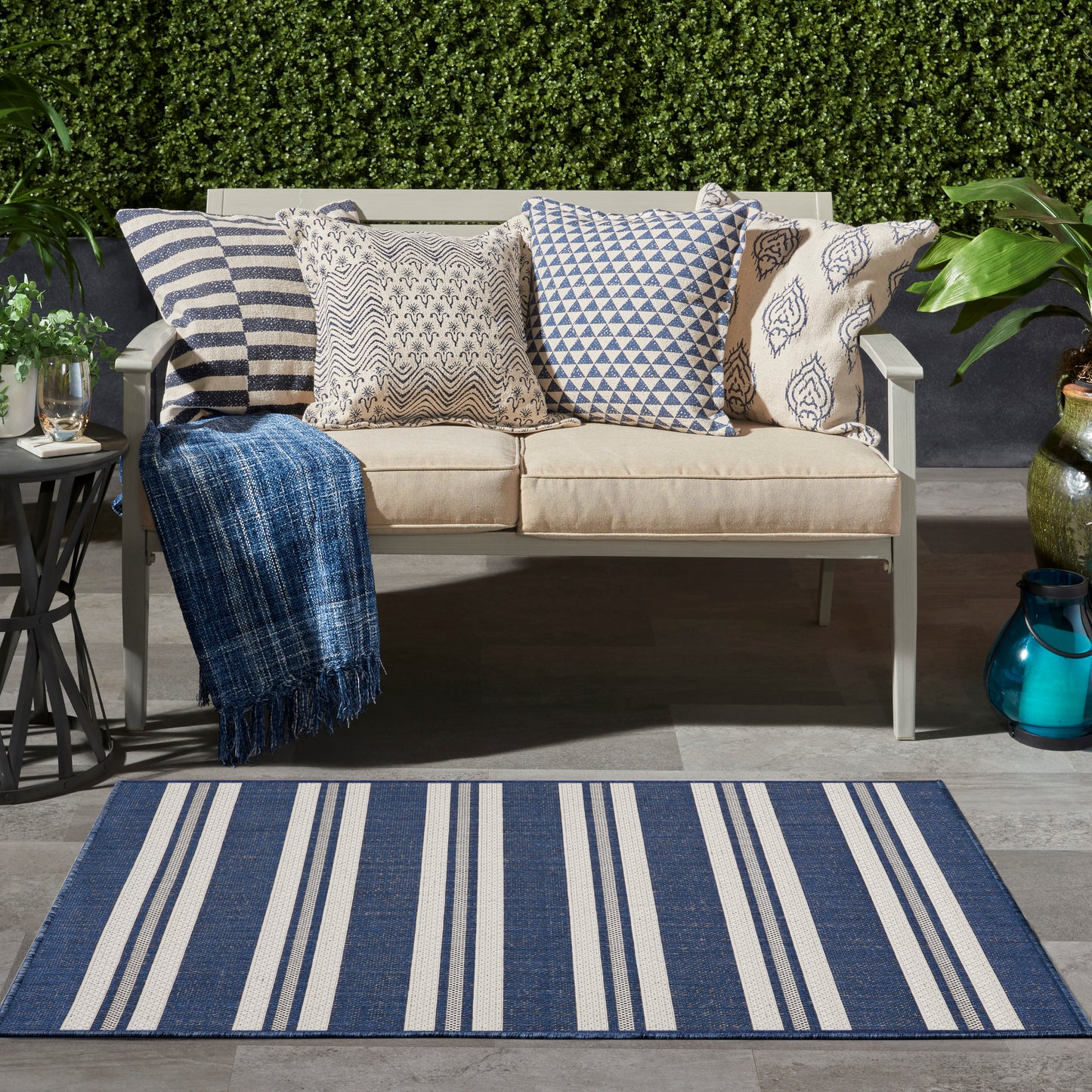 Outdoor beige rug with a subtle pattern in a garden setting.