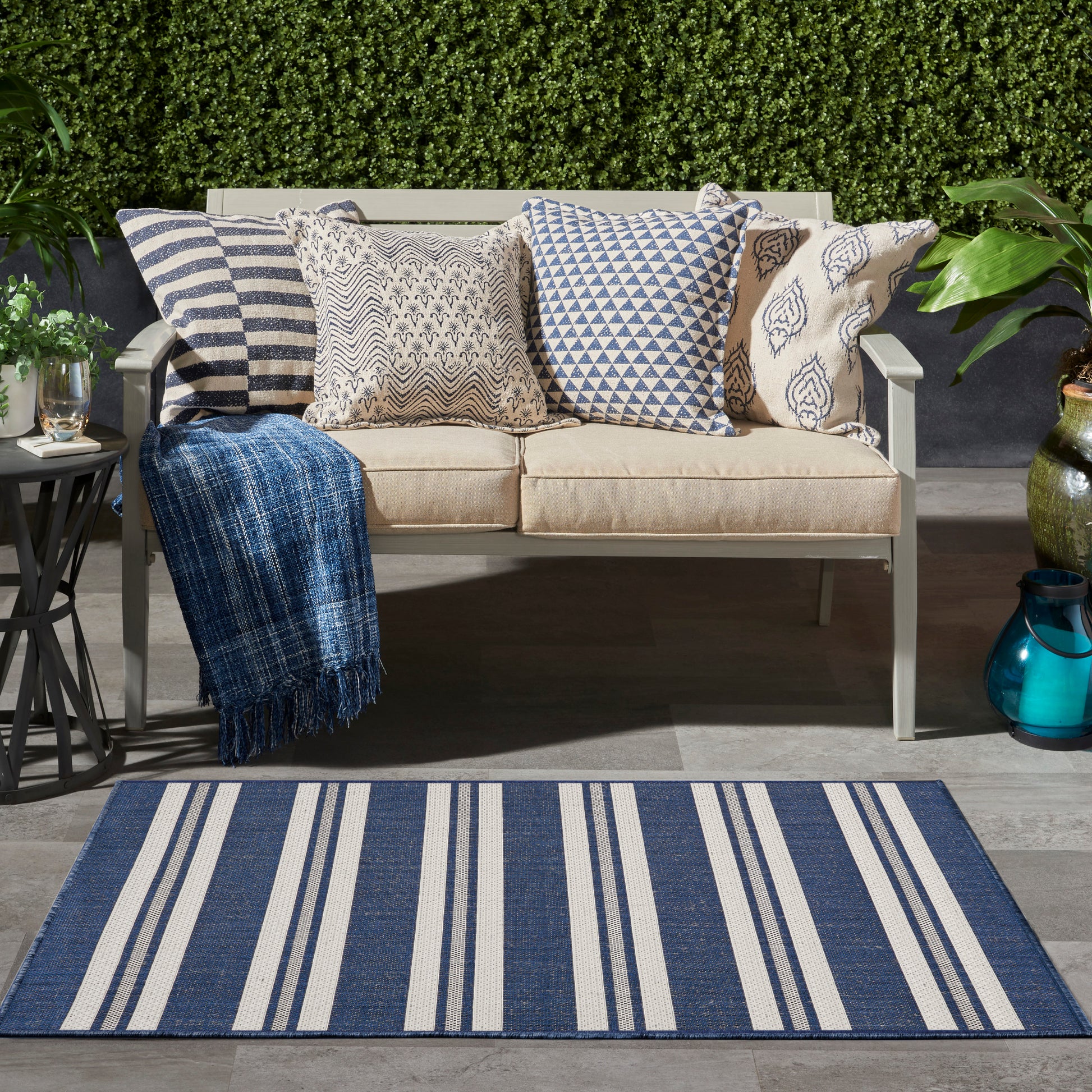 Outdoor beige rug with a subtle pattern in a garden setting.
