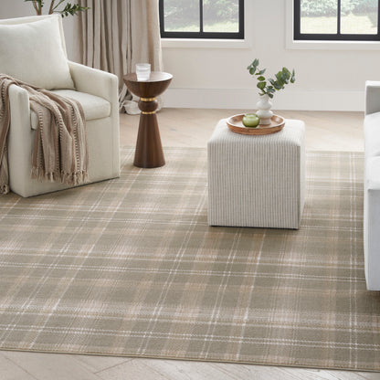 Cozy neutral living room with beige plaid rug, cream sofa, wooden pedestal side table, and fabric ottoman with a tray and greenery