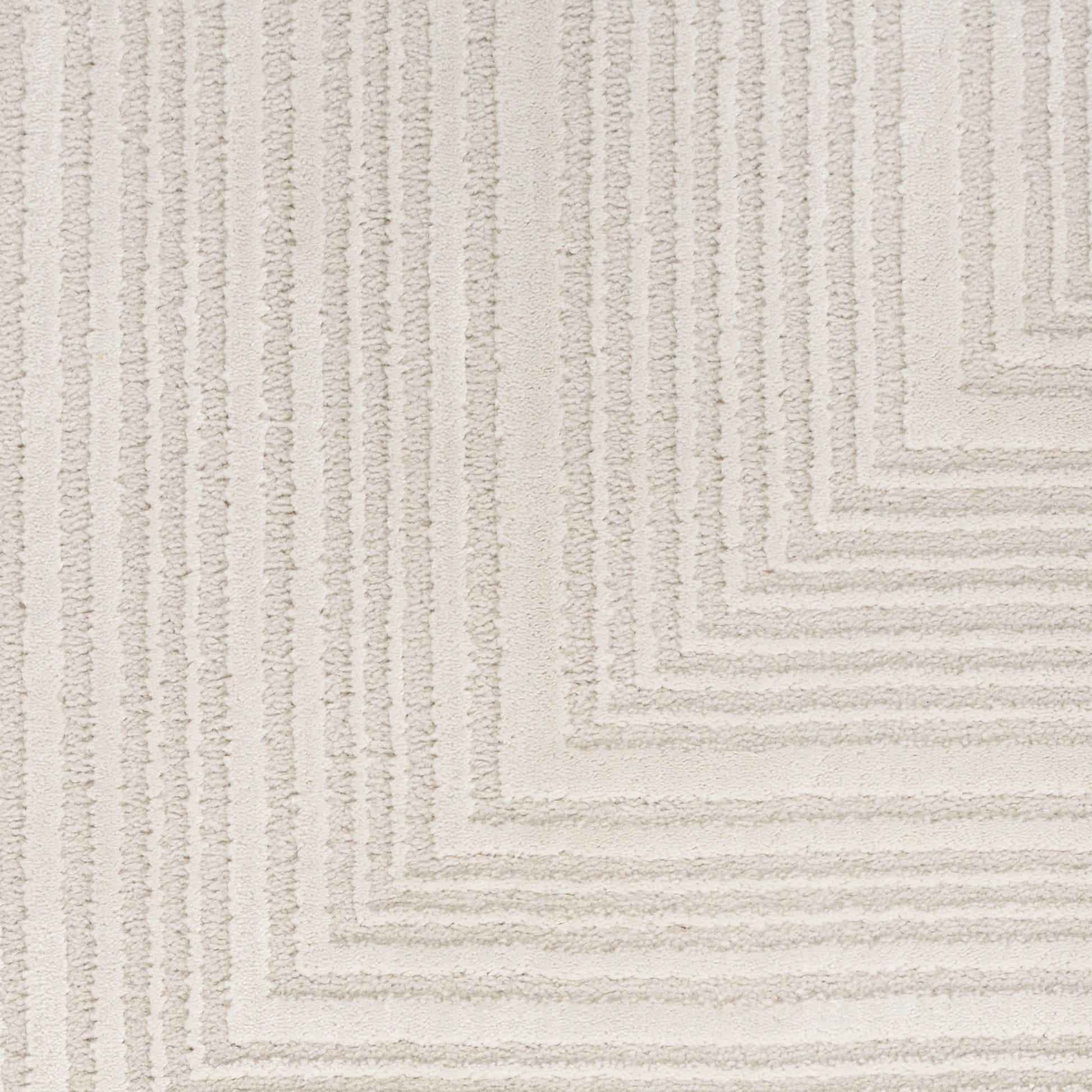 Beige textured area rug with raised geometric square border pattern; soft, neutral living-room style.