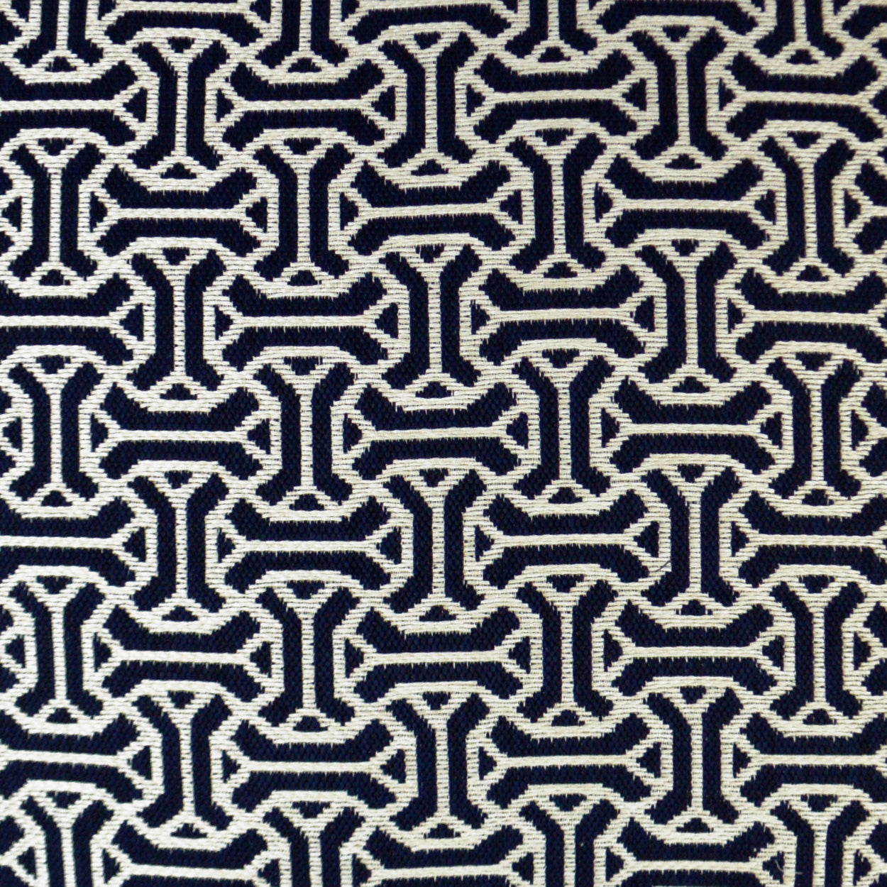 Navy fabric featuring a white interlocking geometric chain pattern in a repeating motif.