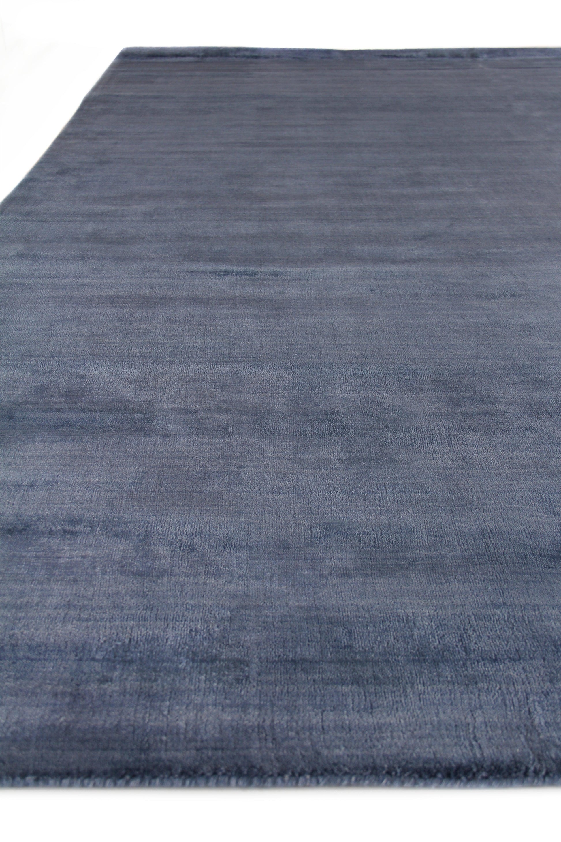 Blue rectangular rug with soft, brushed texture; modern living room decor.