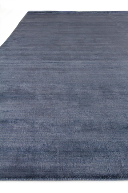Blue rectangular rug with soft, brushed texture; modern living room decor.