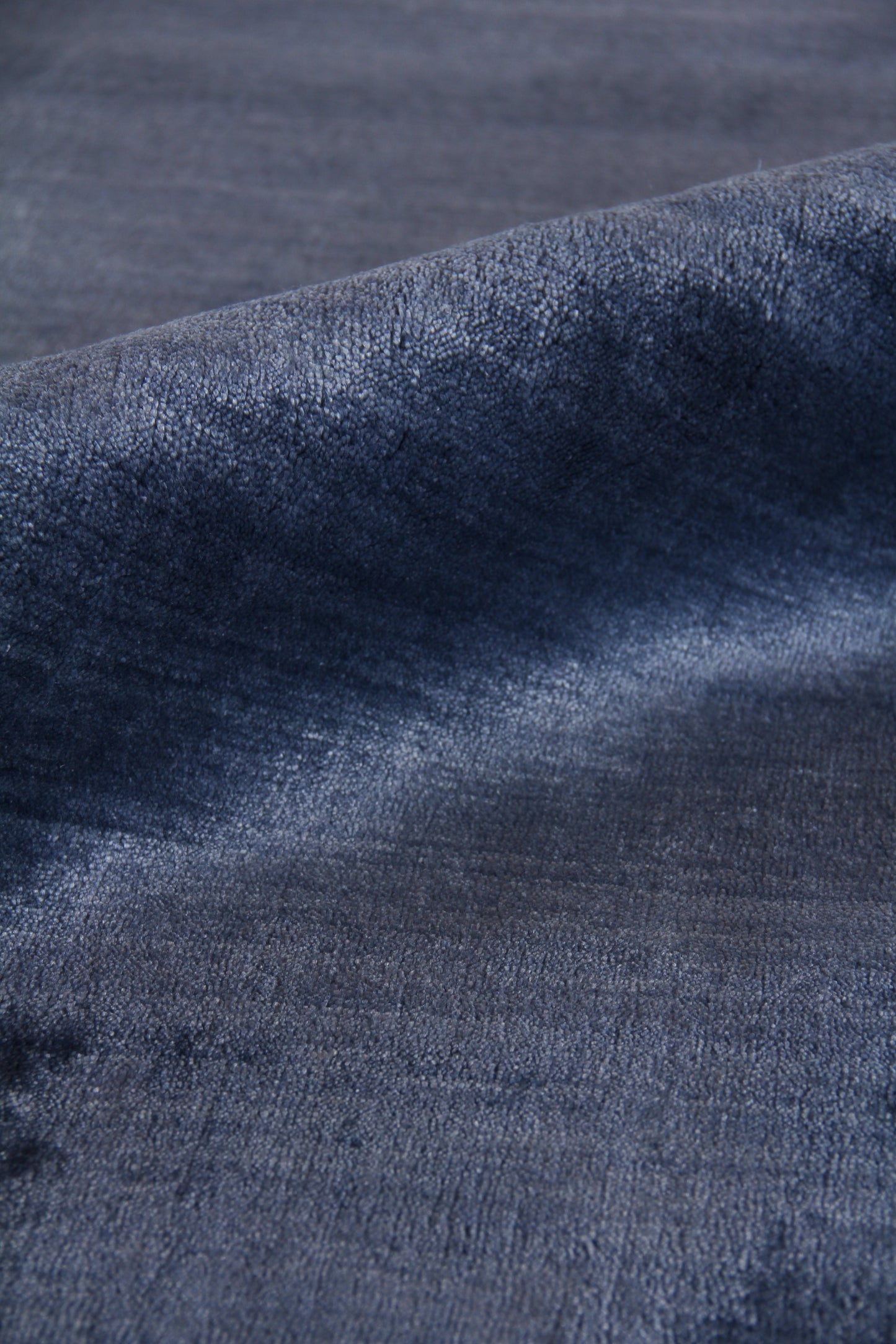 Close-up of a dark indigo rug with a textured, hand-loomed weave.