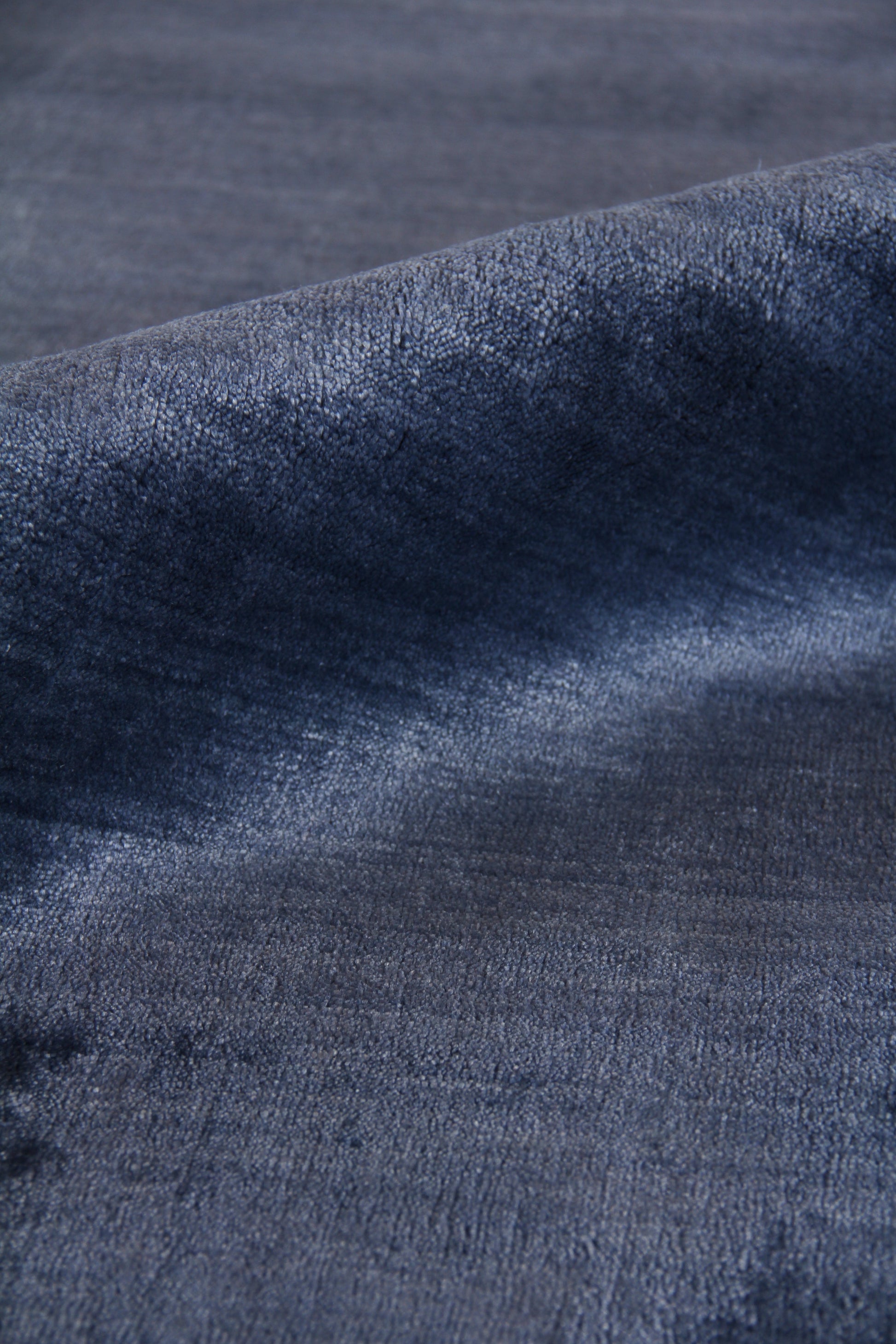 Close-up of a dark indigo rug with a textured, hand-loomed weave.