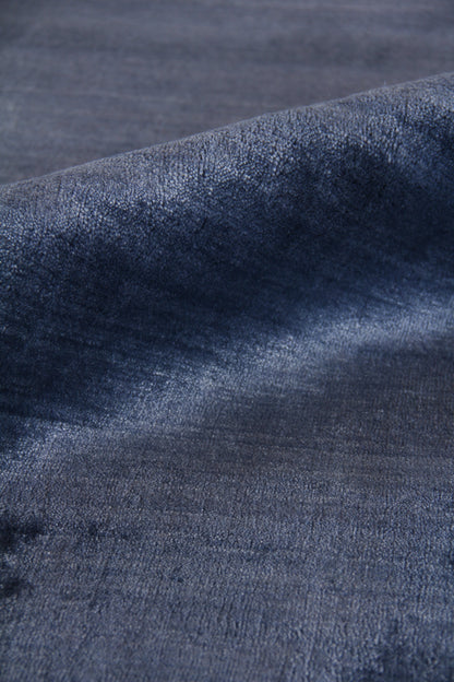 Close-up of a dark indigo rug with a textured, hand-loomed weave.