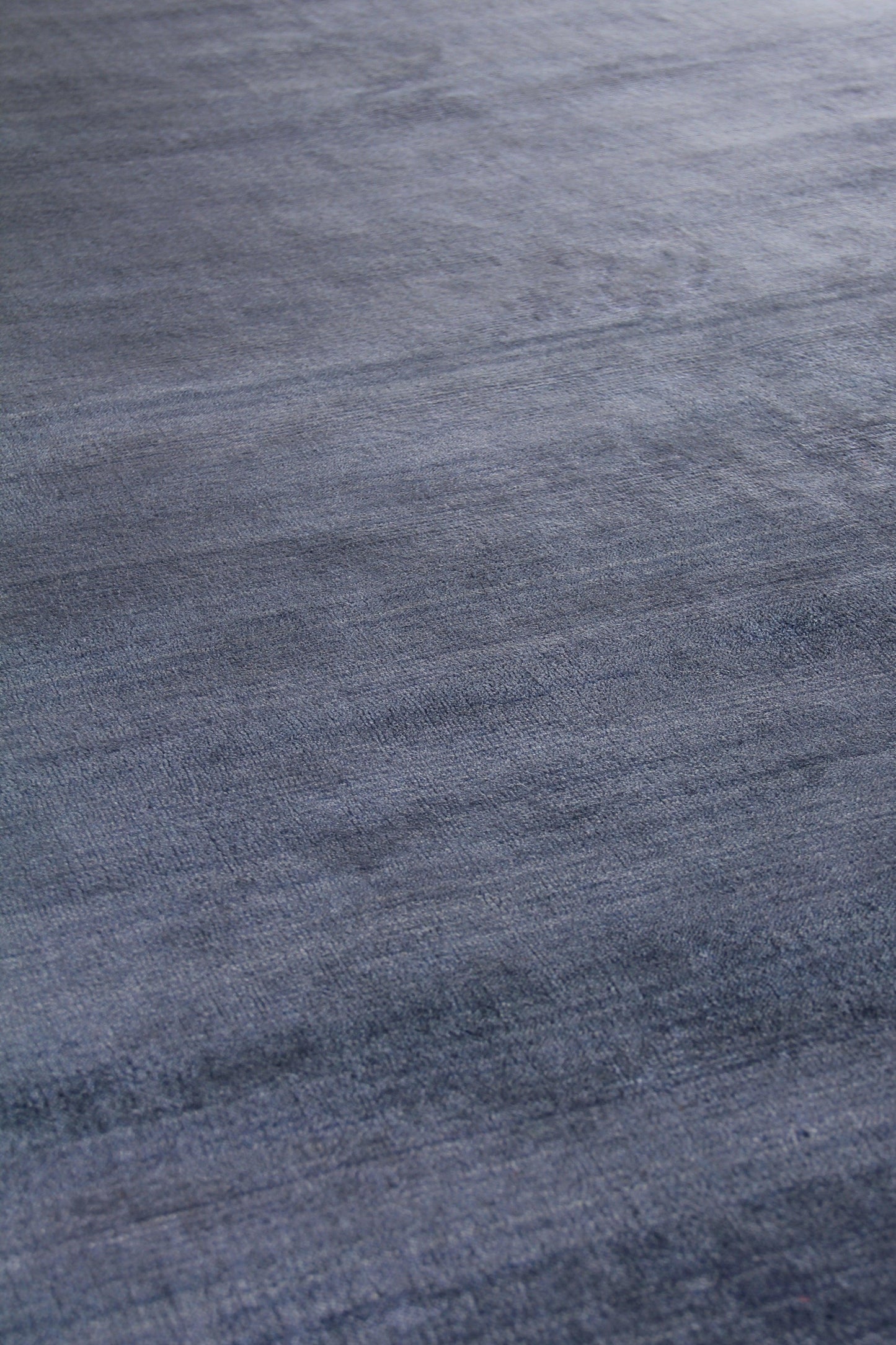 Blue-gray woven rug texture with soft brushed nap and subtle tonal variation; cozy area rug.