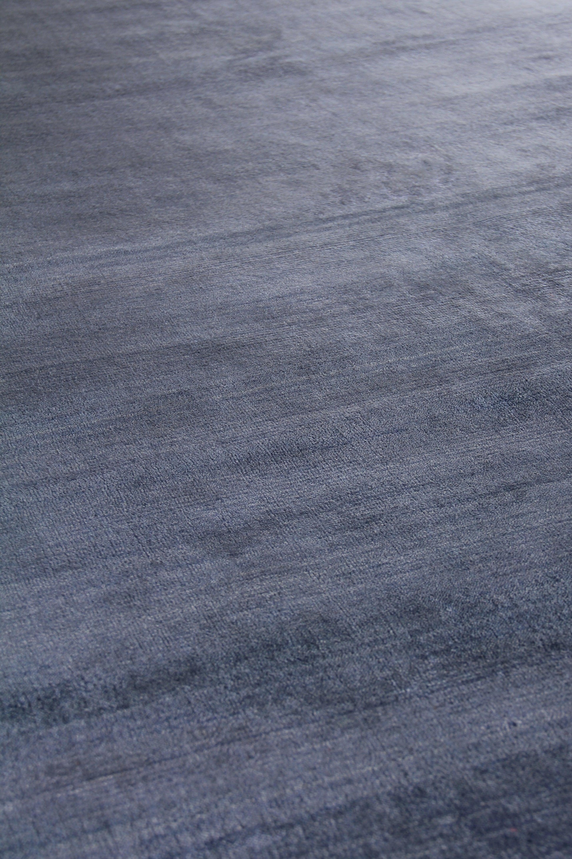 Blue-gray woven rug texture with soft brushed nap and subtle tonal variation; cozy area rug.