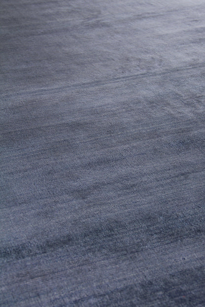 Blue-gray woven rug texture with soft brushed nap and subtle tonal variation; cozy area rug.