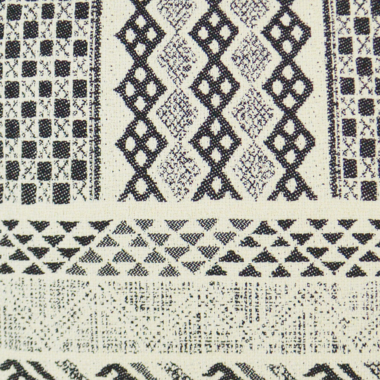 Cream woven fabric with bold black geometric patterns: diamonds, lattices and triangular bands.