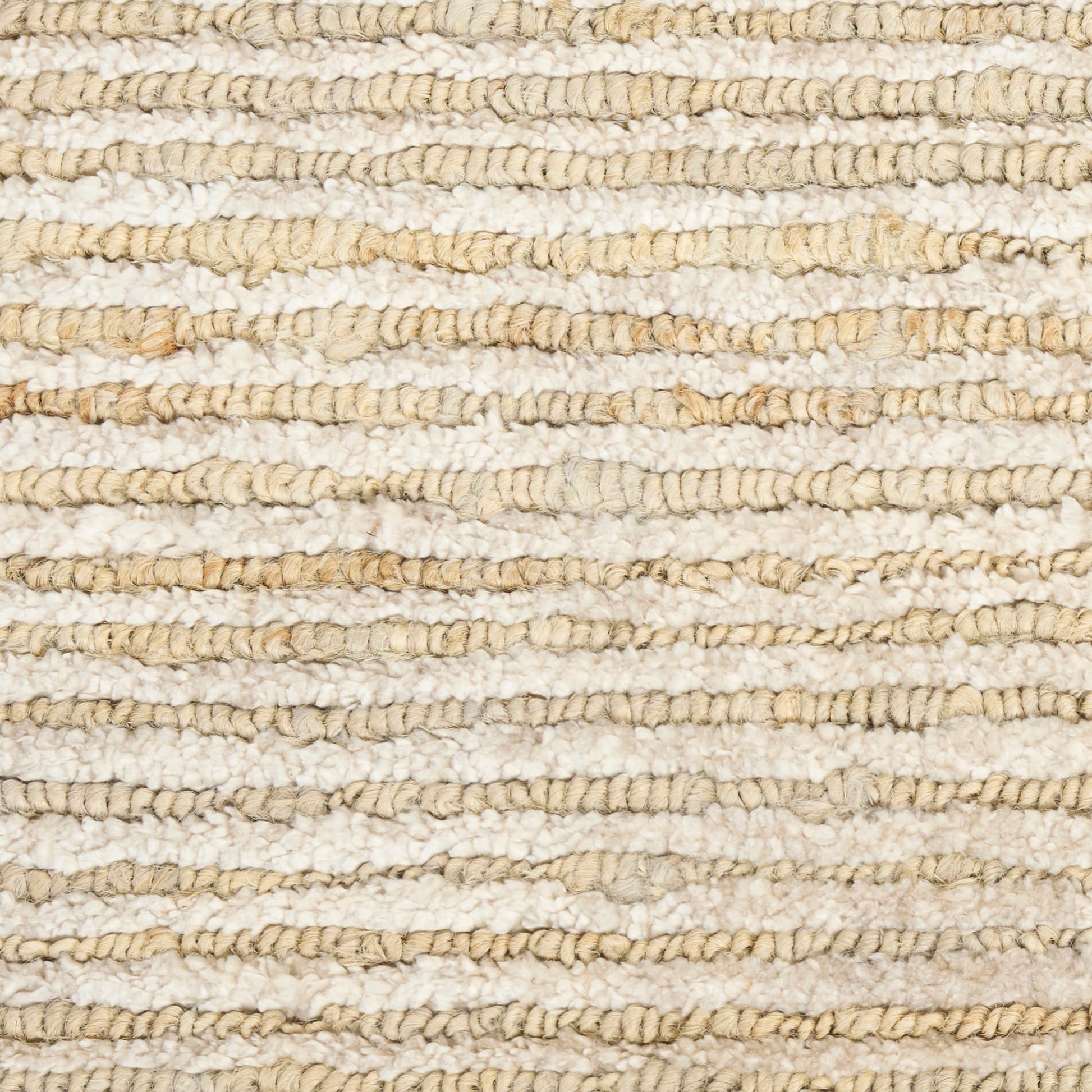 Beige natural fiber rug close-up with looped braided texture; rustic coastal floor covering.
