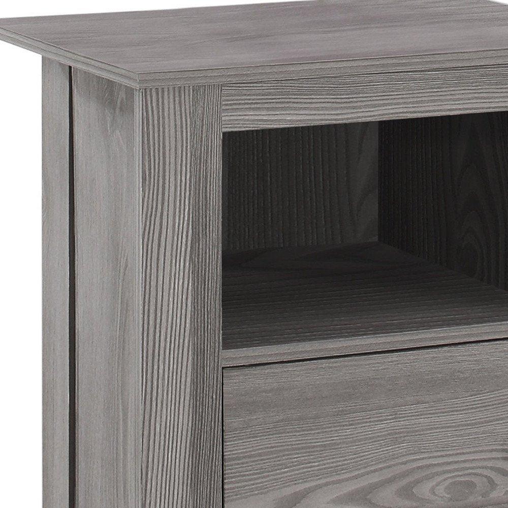 Gray-washed wood end table with top, open middle shelf and bottom drawer.