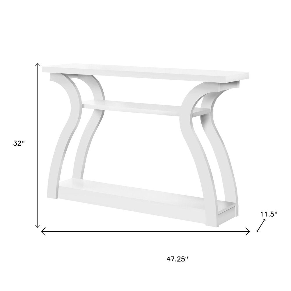 White wooden console table with curved arch legs & two-tier shelves; 47.25 inches wide, 32 inches tall, 11.5 inches deep.