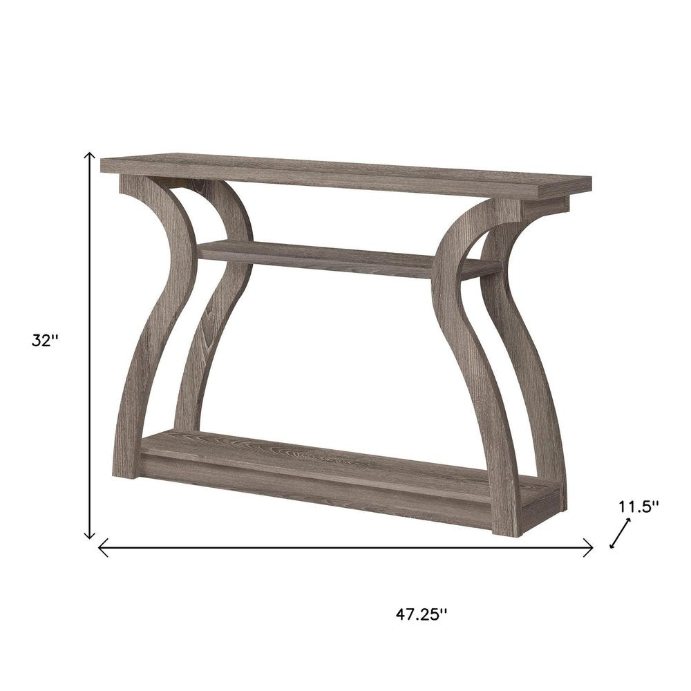 Taupe-toned wood console table with curved trestle legs and a lower shelf.