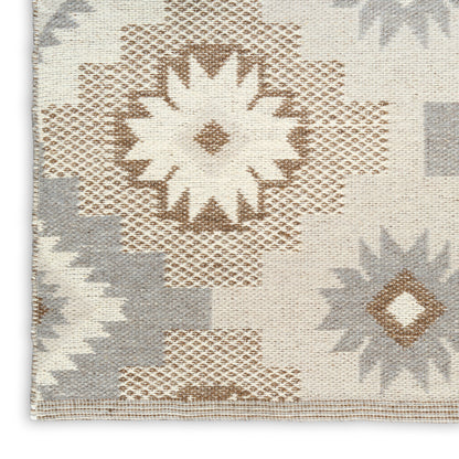 Kilim-style woven rug with cream backdrop and tan, taupe, gray geometric starburst motifs.