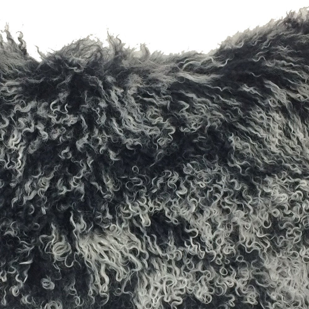 Close-up of black Tibetan lamb fur pillow with microsuede backing, showing dense, fluffy fur (17-inch).