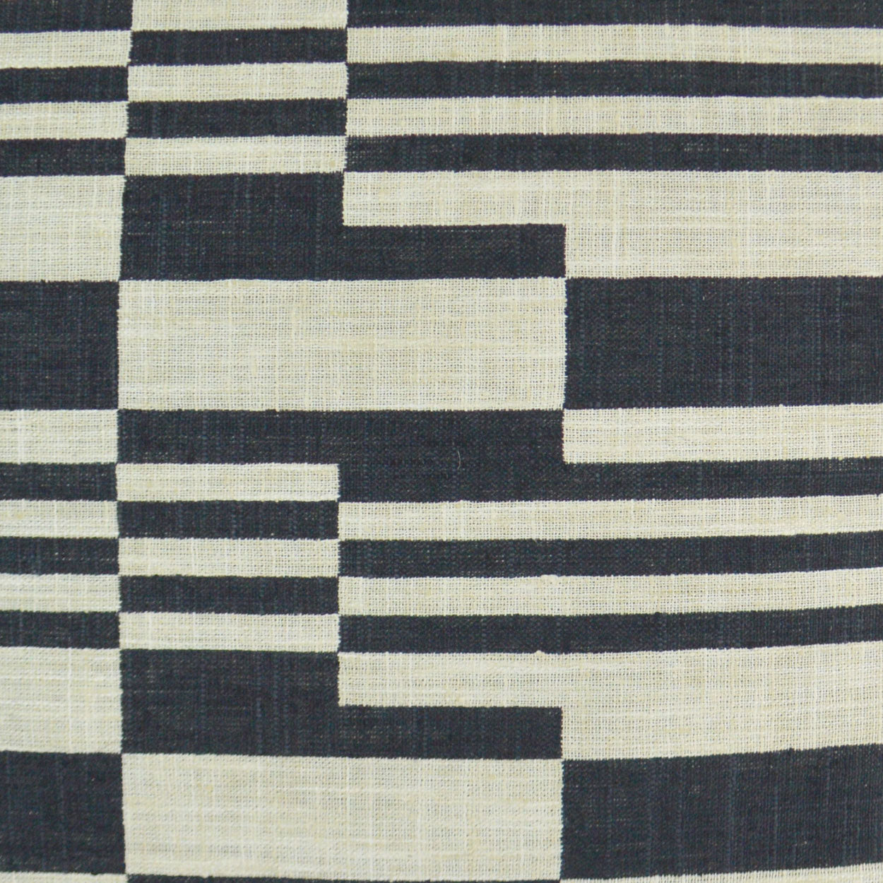 Black and cream geometric woven fabric with stepped horizontal blocks; bold modern upholstery textile.