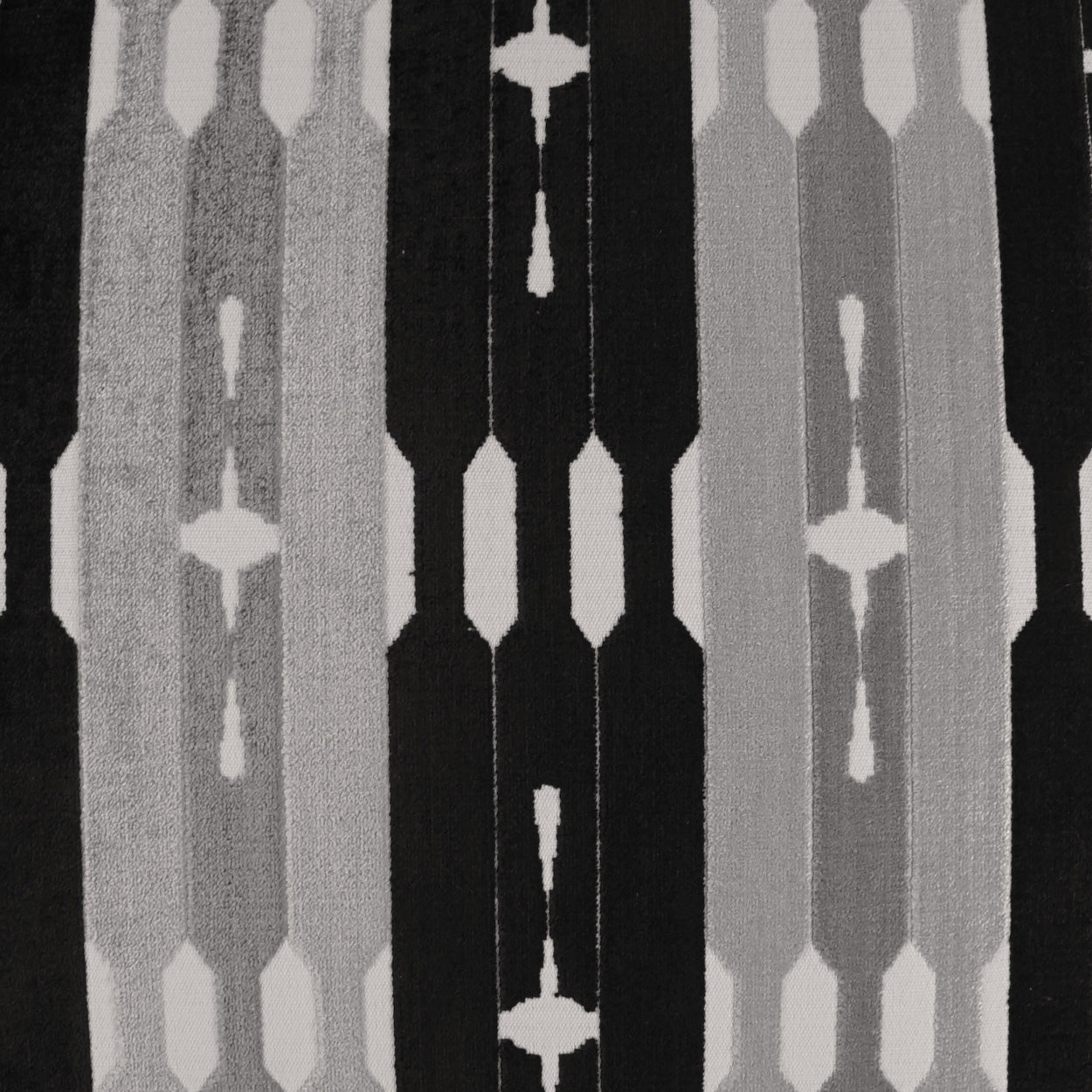 Black and gray geometric fabric with vertical column motifs and white diamond crosses; modern upholstery textile.