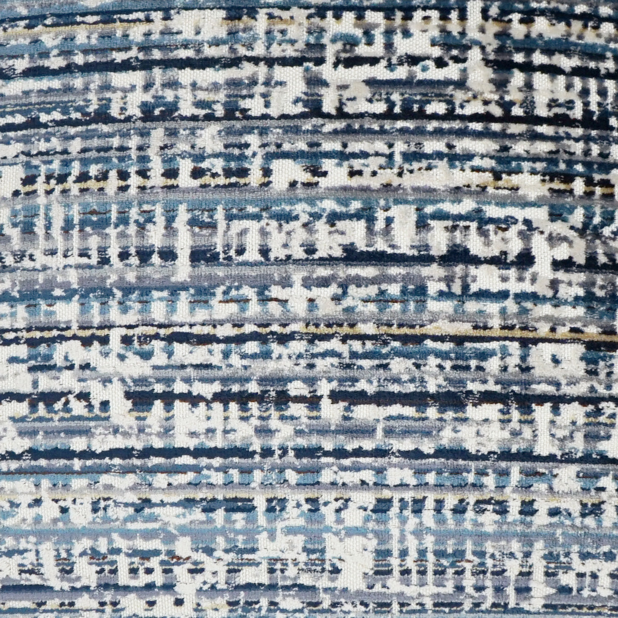 Close-up of a blue-gray abstract striped rug fabric with white and beige accents.