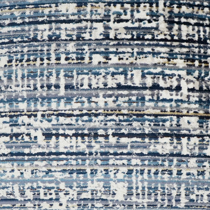 Close-up of a blue-gray abstract striped rug fabric with white and beige accents.
