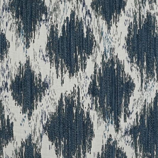 Ikat-inspired woven fabric in navy and blue on cream background; geometric diamond pattern for upholstery.