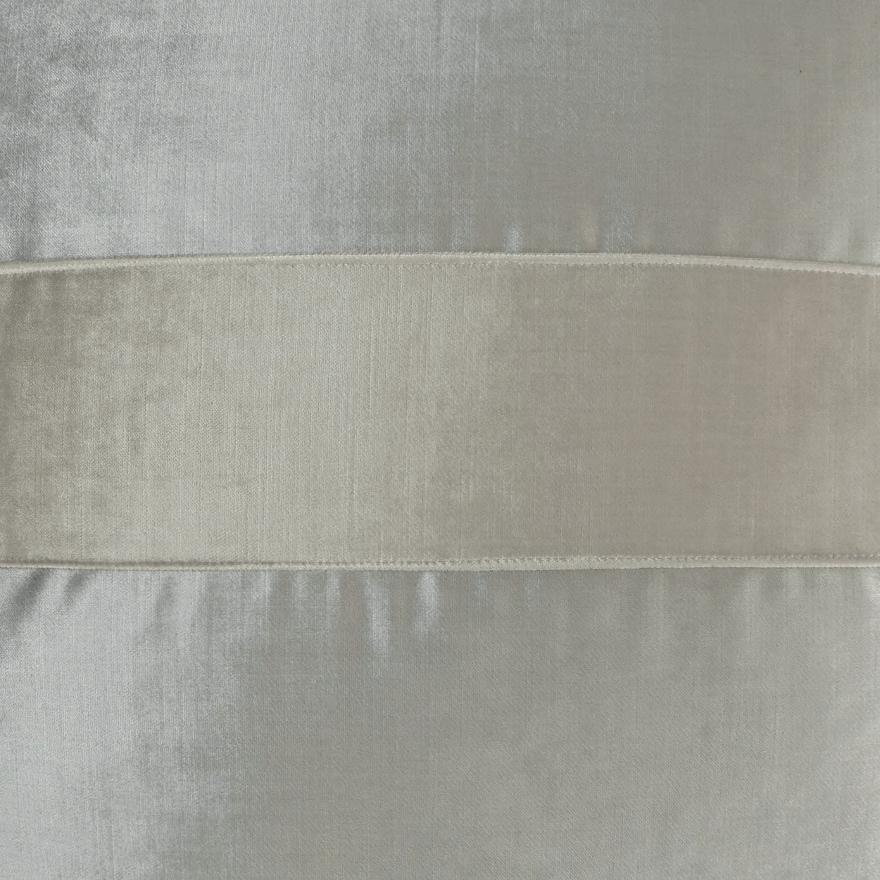 Close-up of light gray velvet fabric with a wide cream horizontal band, soft textile sample.