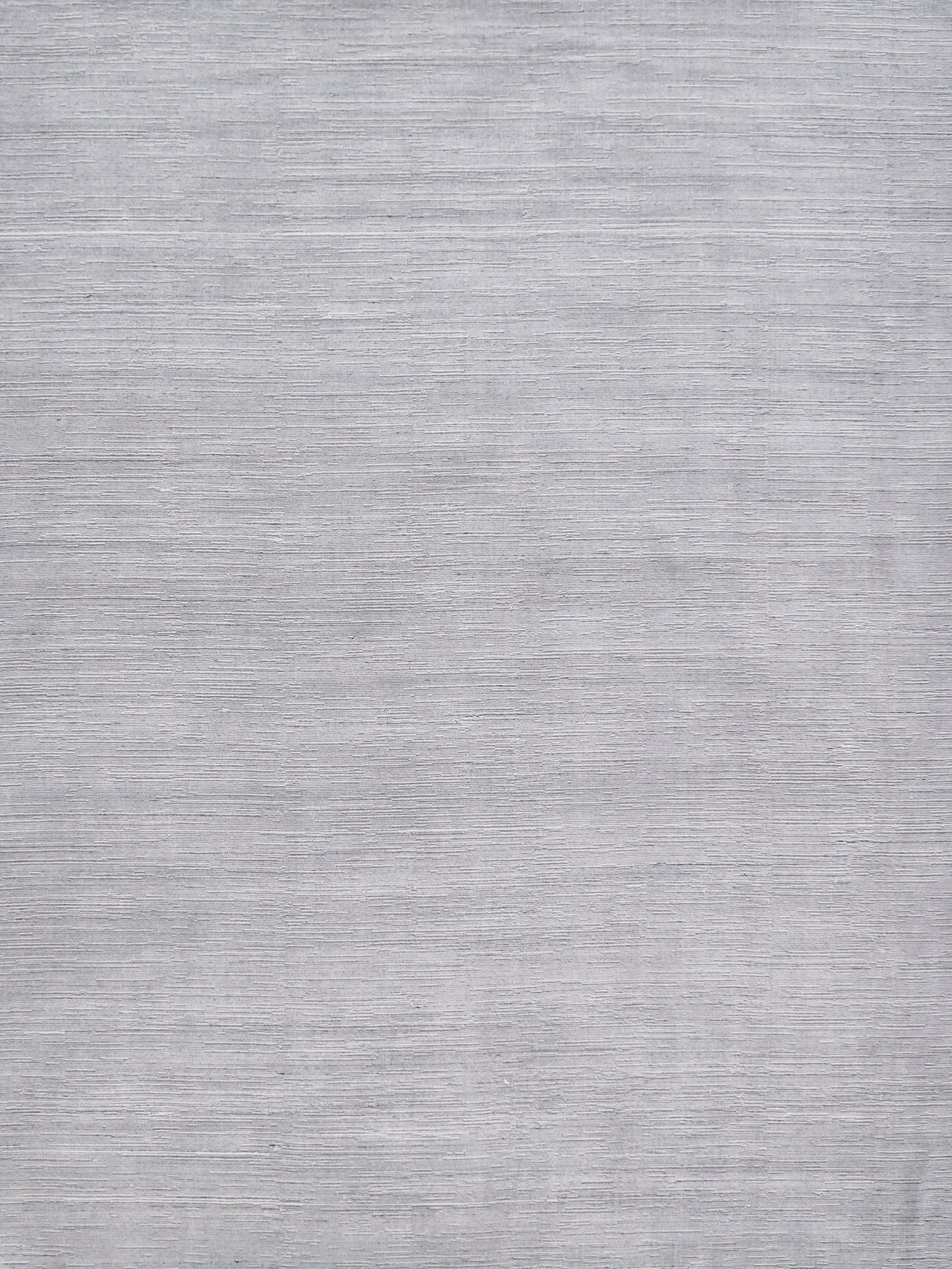 Light gray rug with a subtle textured surface and neutral modern look.
