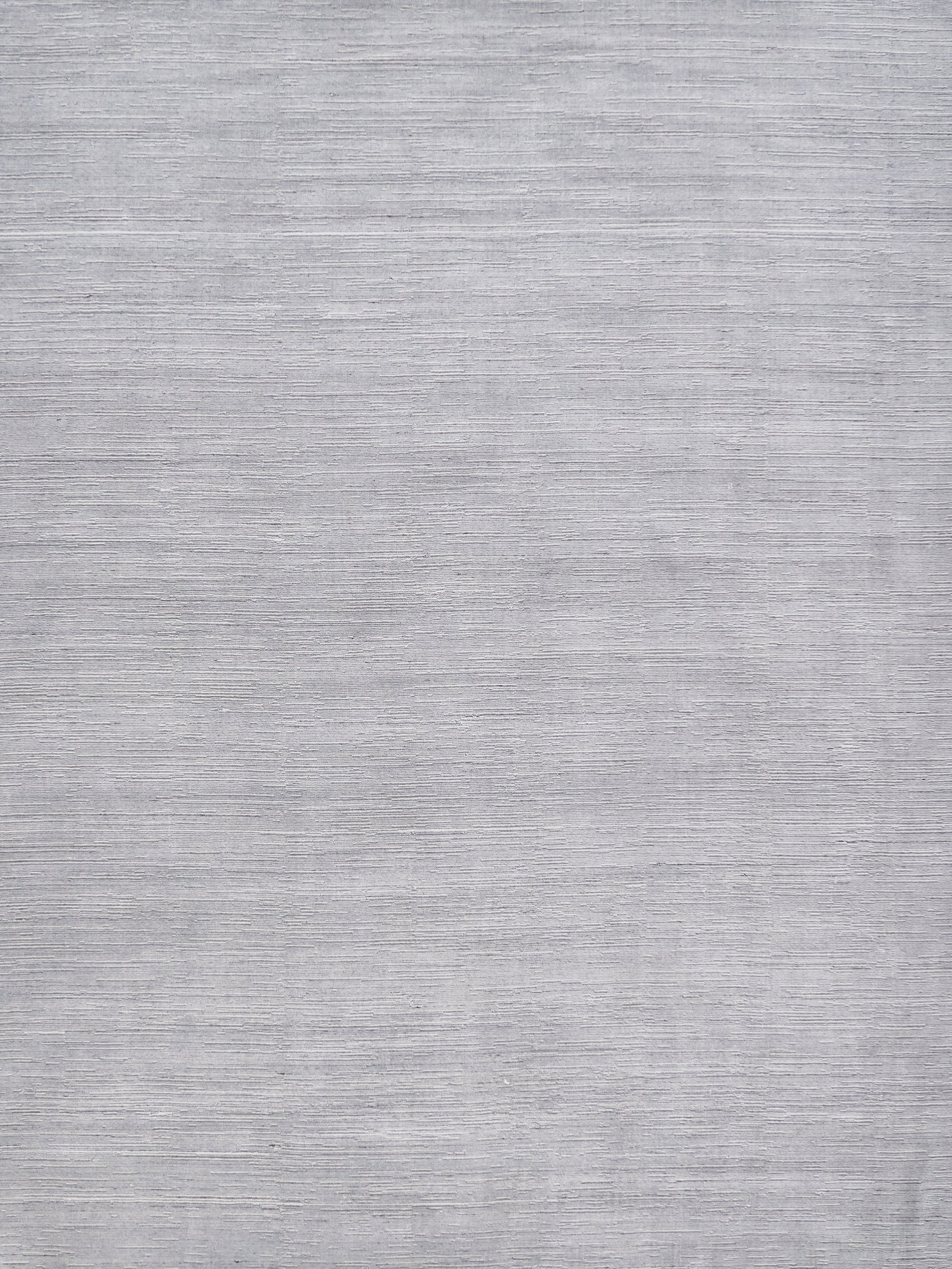 Light gray rug with a subtle textured surface and neutral modern look.