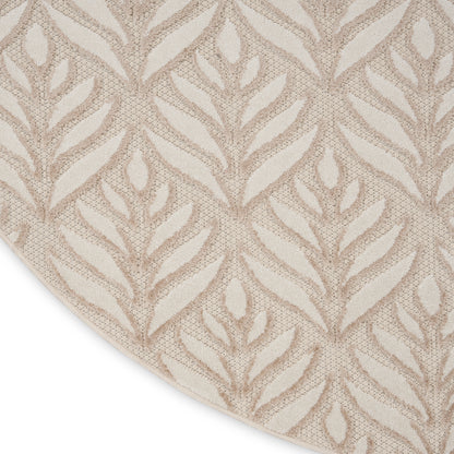 Beige circular rug with repeated leafy jacquard pattern; soft woven texture, neutral decor accent.