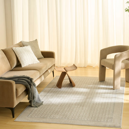 Neutral living room: tan sofa, textured cushions, light gray rug, sculptural wooden coffee table, beige armchair.