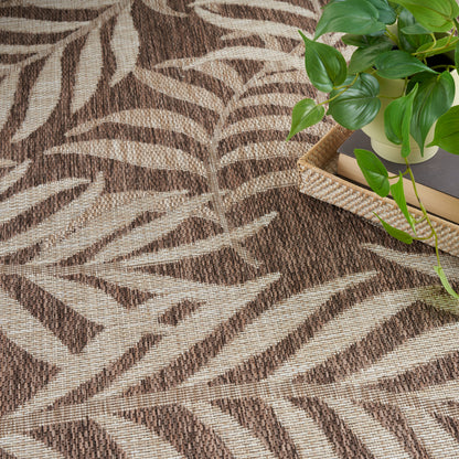 Brown and beige zebra-pattern woven rug with a green potted plant on a wicker tray with books.
