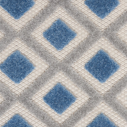 Geometric rug pattern with blue diamond shapes framed by light gray diamonds on a beige woven background.