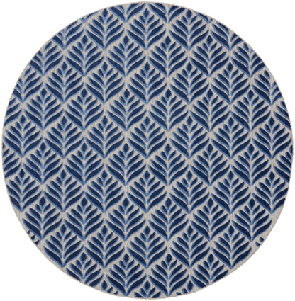 Round rug with navy blue leaf pattern on beige background; repeating botanical motif.
