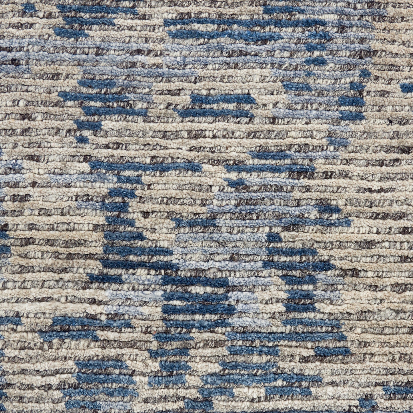 Beige woven rug with blue geometric pattern; textured pile for a soft rustic look.