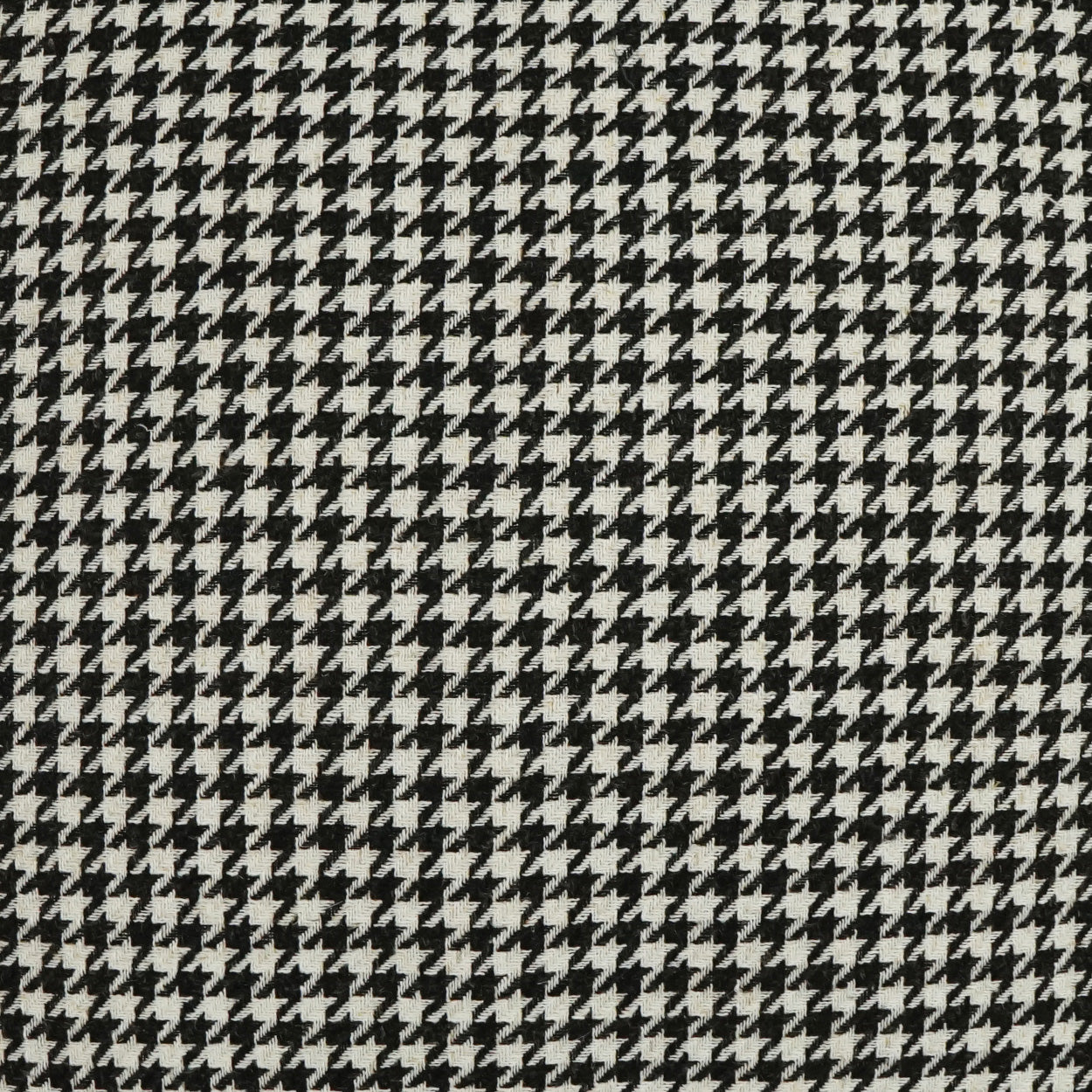 Close-up of black & white houndstooth fabric; woven textile pattern ideal for suits or coats.