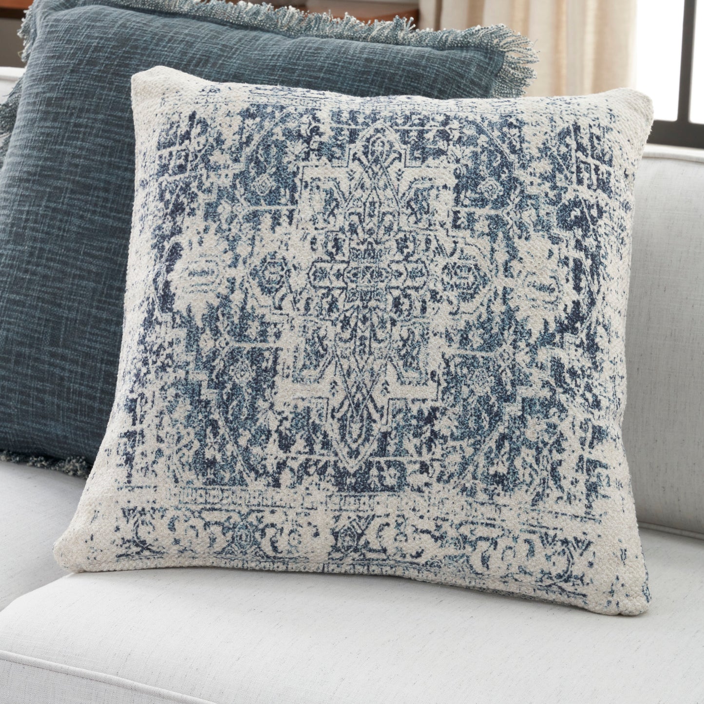 Square ivory pillow with distressed indigo rug pattern, woven cotton, decorative for sofa or bed.