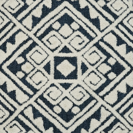 Gray fabric swatch, square, atop a navy blue and white geometric rug.