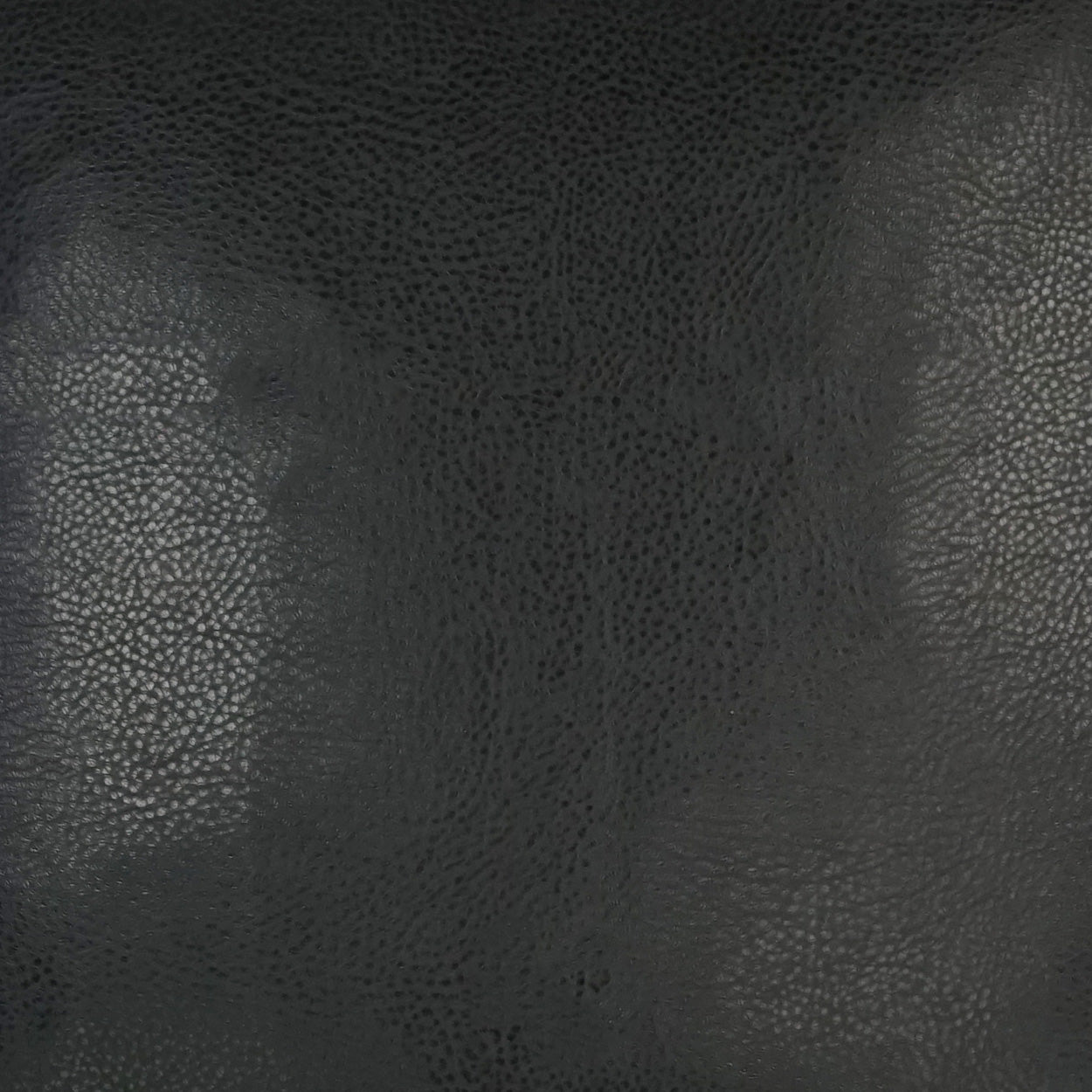 Close-up of dark pebbled leather texture with a subtle sheen, suitable for upholstery or accessories.