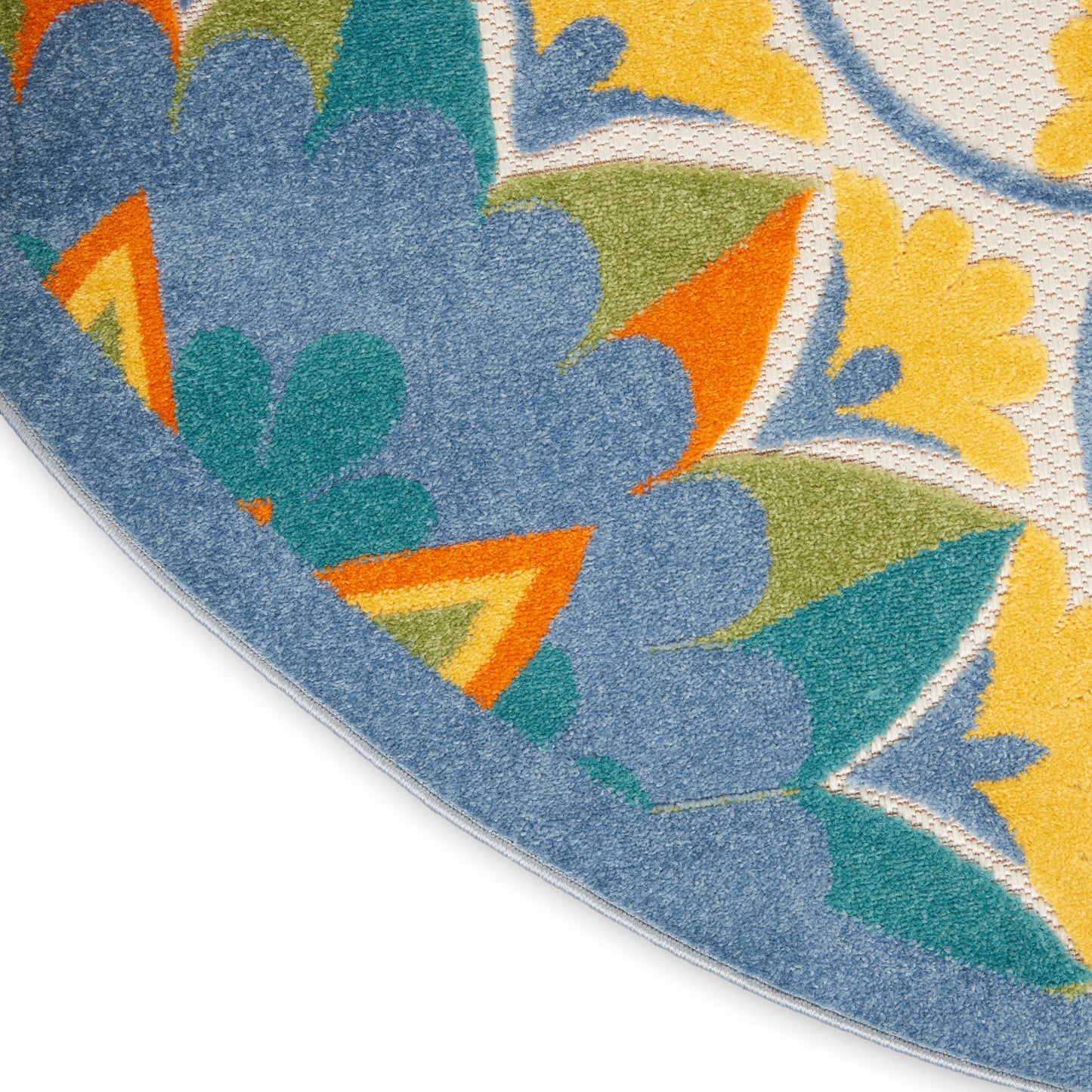 Round rug with vivid multicolor floral pattern; blue border, yellow, orange and green petals, soft textured surface.
