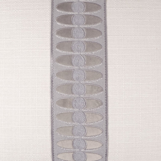 Lavender satin trim with repeated oval embroidered motifs on beige fabric.