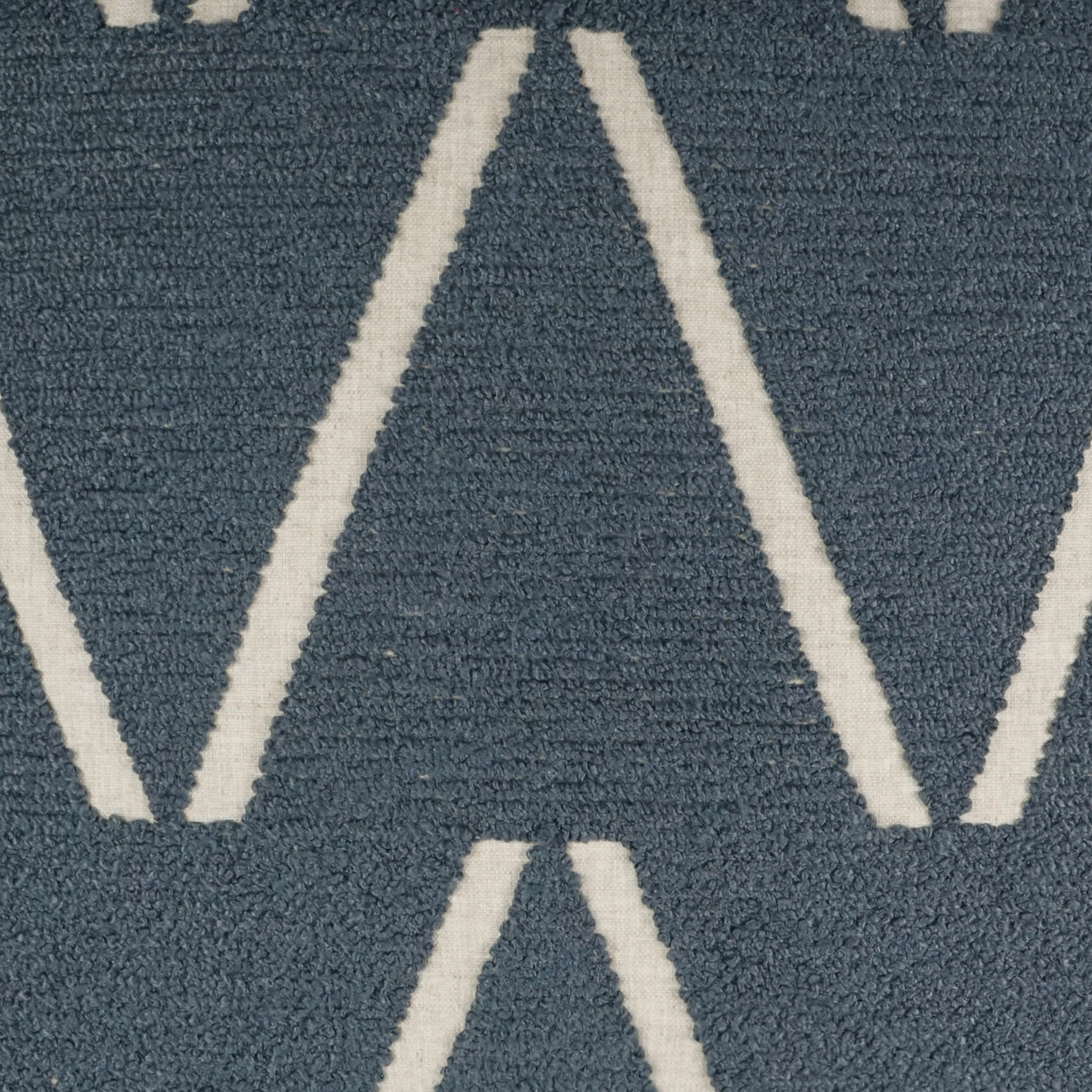 Blue woven rug with white chevron zigzag pattern and textured loop pile.