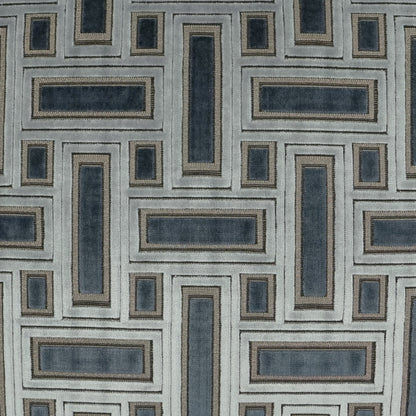Geometric navy and blue-gray interlocking rectangle pattern with tan borders on light gray upholstery fabric.