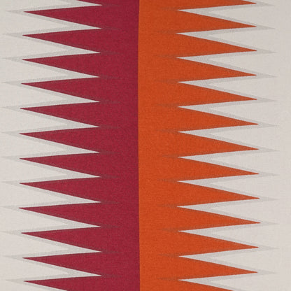 Geometric zigzag fabric with burgundy and orange vertical panels and white triangles on beige background.